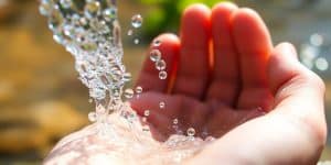Clear water splashing into a cupped hand